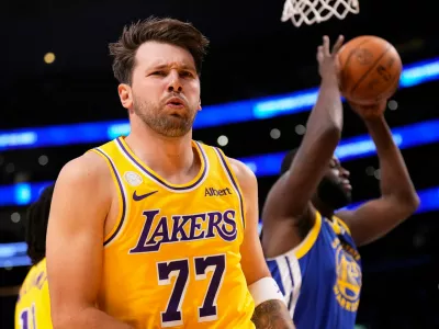 Los Angeles Lakers forward/guard Luka Doncic, left, looks to fans after scoring as Golden State Warriors forward/center Draymond Green takes the ball during the first half of an NBA basketball game Wednesday, Oct. 21, 2026, in Los Angeles. (AP Photo/Mark J. Terrill)