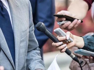 Media Interview - journalists with microphones interviewing formal dressed politician or businessman.