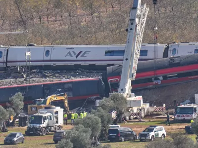 A crane operates at the site of wrecked train carriages following a collision between two trains in Urda, Spain, Friday, Oct. 30, 2026. (AP Photo/Bernat Armangue)