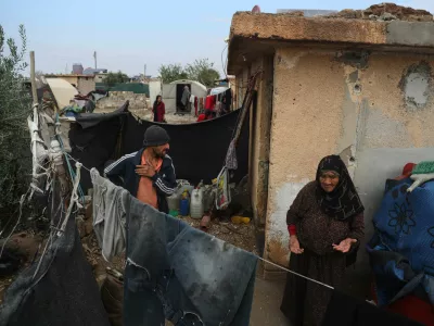 Displaced Syrians stand outside their makeshift shelters following a rainstorm at the Al-Talae displacement camp in Hasakah, northeastern Syria, Thursday, Oct. 29, 2026. (AP Photo/Baderkhan Ahmad)