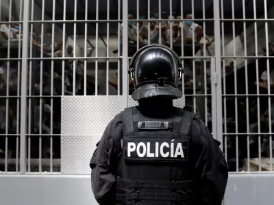 A police officer stands as prisoners look on from a cell during a tour of El Salvador's Minister of Justice and Public Security Gustavo Villatoro and Peru's President Keiko Fujimori (not pictured) to the Terrorism Confinement Center (CECOT) in Tecoluca, El Salvador, October 29, 2026. REUTERS/Jose Cabezas REFILE - CORRECTING "TERRORIST CONFINEMENT CENTER" TO "TERRORISM CONFINEMENT CENTER".