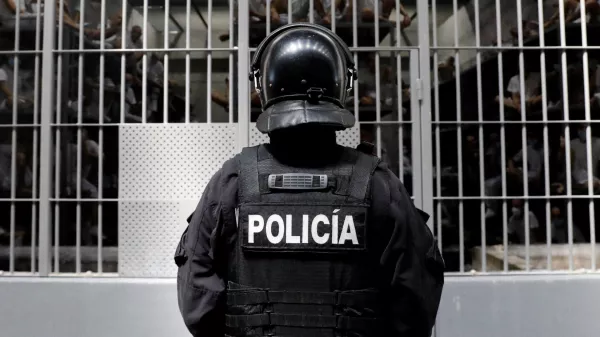 A police officer stands as prisoners look on from a cell during a tour of El Salvador's Minister of Justice and Public Security Gustavo Villatoro and Peru's President Keiko Fujimori (not pictured) to the Terrorism Confinement Center (CECOT) in Tecoluca, El Salvador, October 29, 2026. REUTERS/Jose Cabezas REFILE - CORRECTING "TERRORIST CONFINEMENT CENTER" TO "TERRORISM CONFINEMENT CENTER".