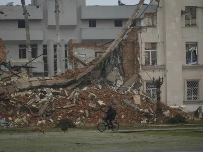 A resident rides a bicycle past a damaged building, amid Russia's attack on Ukraine, in the frontline city of Kherson, Ukraine, October 30, 2026. REUTERS/Nina Liashonok