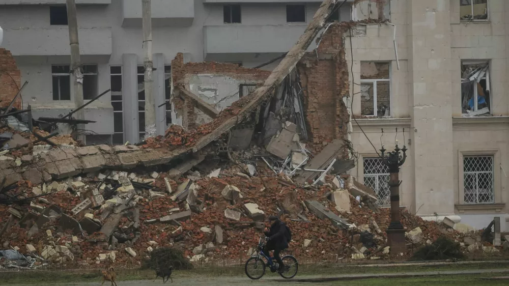 A resident rides a bicycle past a damaged building, amid Russia's attack on Ukraine, in the frontline city of Kherson, Ukraine, October 30, 2026. REUTERS/Nina Liashonok