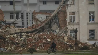 A resident rides a bicycle past a damaged building, amid Russia's attack on Ukraine, in the frontline city of Kherson, Ukraine, October 30, 2026. REUTERS/Nina Liashonok