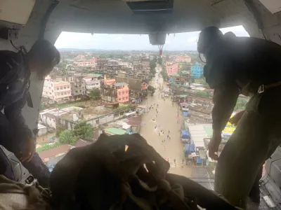 Members of Indian Air Force (IAF) drop relief goods from a plane in the flood-affected areas in Silchar in the northeastern state of Assam, India, June 23, 2022. Picture taken June 23, 2022. Indian Air Force/Handout via REUTERS THIS IMAGE HAS BEEN SUPPLIED BY A THIRD PARTY. NO RESALES. NO ARCHIVES.