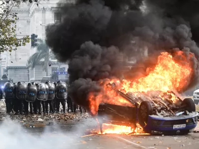 12 June 2024, Argentina, Buenos Aires: A Volkswagen car burns in front of Congress during a protest against the reform plan of President Milei's ultra-liberal government, which is being debated in Congress. Among other things, the plan provides for new regulations for high investments and a more flexible labour market. Photo: Fernando Gens/dpa