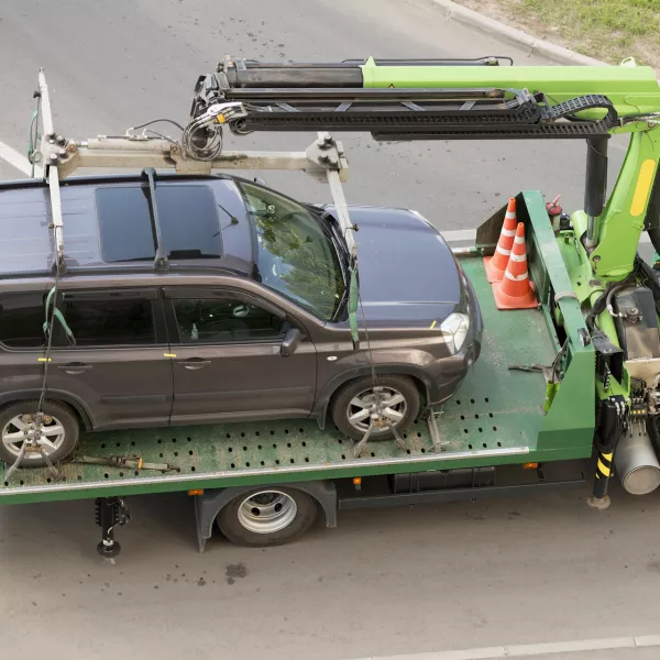 ﻿Moscow, Russia - May 22, 2019: Tow truck lifting the Nissan car for improper parking. Image can be used for topics like traffic offense, travel, traffic laws, traffic rules, iniquity, lawlessness, infringement of rights, business, help