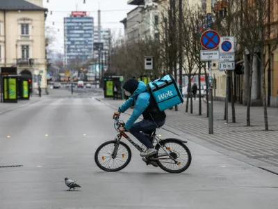 Slovenska cesta - kolesar z masko  dostava hrane Wolt prepovedano zbiranje in gibanje na javnih povrinah in prepoved dostopa na javna mesta ter uvedba globe za kritelje - 25.03.2020 - Koronavirus COVID-19 v Sloveniji - epidemija - ukrepi za preprečevanje irjenja okub s koronavirusom - ustavljeno javno in druabno ivljenje. //FOTO: 