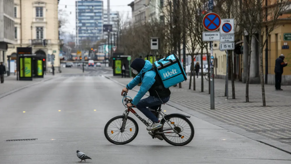 Slovenska cesta - kolesar z masko  dostava hrane Wolt prepovedano zbiranje in gibanje na javnih povrinah in prepoved dostopa na javna mesta ter uvedba globe za kritelje - 25.03.2020 - Koronavirus COVID-19 v Sloveniji - epidemija - ukrepi za preprečevanje irjenja okub s koronavirusom - ustavljeno javno in druabno ivljenje. //FOTO: 