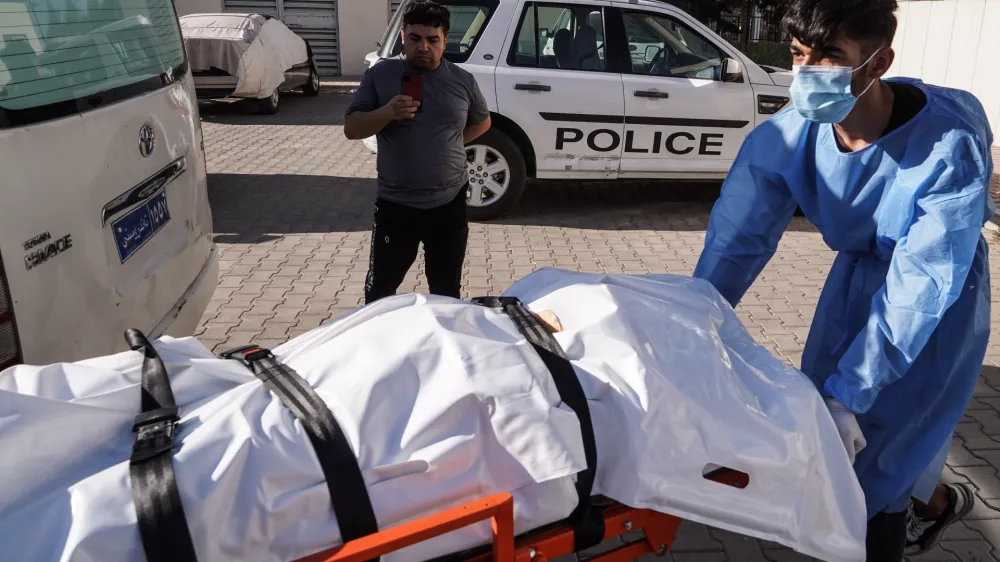 20 July 2022, Iraq, Zakho: A medic transports the body of a victim killed in a Turkish shelling on a tourist resort in northern Iraq. At least eight civilians were killed and 20 others injured in a Turkish artillery shelling that struck a tourist resort in the village of Parakh in the Kurdish province of Duhok. Photo: Ismael Adnan/dpa