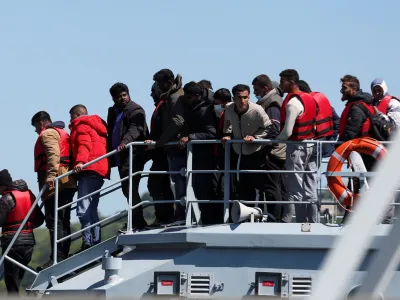 FILE PHOTO: Migrants disembark at the Port of Dover, after being rescued while crossing the English Channel, in Dover, Britain, June 14, 2022. REUTERS/Matthew Childs/File Photo