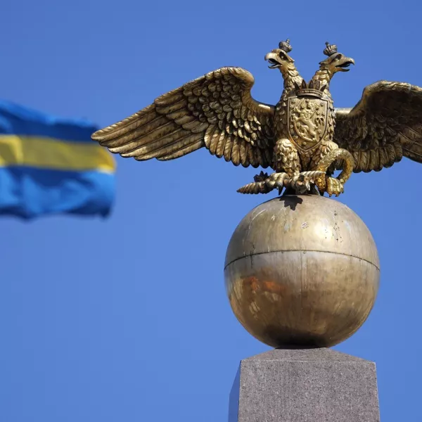 A Russian Imperial double-headed eagle is seen in front of a Sweden flag on the Czarina's Stone in the Market Square, in Helsinki, Finland, Friday, May 13, 2022. Finnish leaders announced Thursday their belief that Finland should join the world's biggest military organization because of Russia's war in Ukraine. Sweden could soon follow suit. (AP Photo/Martin Meissner)