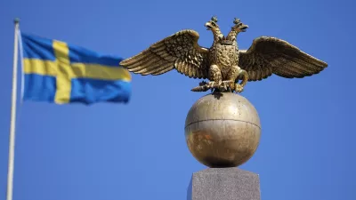 A Russian Imperial double-headed eagle is seen in front of a Sweden flag on the Czarina's Stone in the Market Square, in Helsinki, Finland, Friday, May 13, 2022. Finnish leaders announced Thursday their belief that Finland should join the world's biggest military organization because of Russia's war in Ukraine. Sweden could soon follow suit. (AP Photo/Martin Meissner)