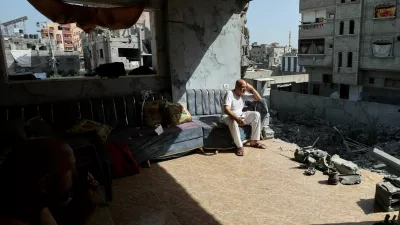 People sit at a ruined building, in the aftermath of Israeli strikes at the area where Israeli hostages were rescued, amid the Israel-Hamas conflict, in Nuseirat refugee camp, central Gaza Strip, June 15, 2024. REUTERS/Ramadan Abed