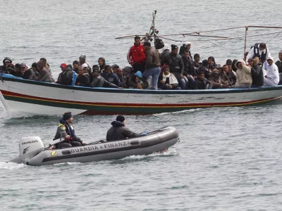 Migrants from North Africa arrive, escorted by Italian Guardia di Finanza, at the southern Italian island of Lampedusa March 14, 2011. Thousands of Tunisians have fled this year in the wake of the uprising that toppled long-time ruler Zine al-Abidine Ben Ali and sparked a wave of upheaval across North Africa and the Middle East. REUTERS/Stefano Rellandini (ITALY - Tags: POLITICS SOCIETY)