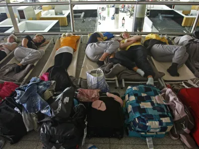 Passengers waiting for a flight to Helsinki sleep on cots at Lisbon's international Portela Airport Monday morning, May 10, 2010. The airport reopened in the late morning after being cosed for ten hours due to an ash cloud drifting over from a volcano in Iceland that caused major air travel chaos last month. (AP Photo/ Francisco Seco)