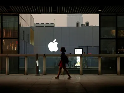 FILE PHOTO: A woman walks past an Apple store in Beijing, China July 28, 2016. REUTERS/Thomas Peter/File Photo