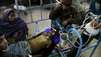 A patient is surrounded by relatives as he takes oxygen and saline while being treated in a hospital after drinking toxic alcohol in Diamond Harbour, near Kolkata, India, Thursday, Dec. 15, 2011. A tainted batch of bootleg liquor has killed scores and sent dozens more to the hospital in villages outside Kolkata, officials said. (AP Photo/Bikas Das)