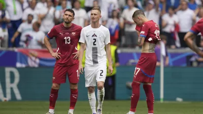 Slovenia's Zan Karnicnik, centre, walks next to Serbia's players after scoring the opening goal of his team against Serbia during a Group C match between Slovenia and Serbia at the Euro 2024 soccer tournament in Munich, Germany, Thursday, June 20, 2024. (AP Photo/Matthias Schrader)