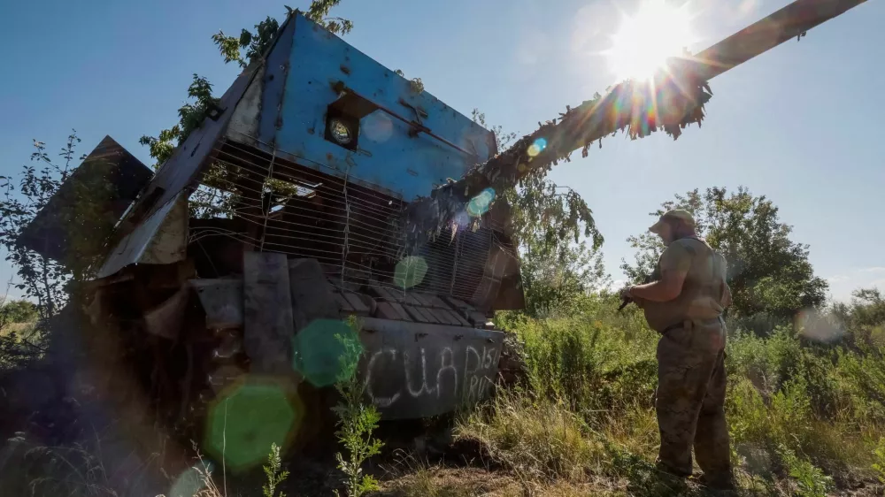 A Ukrainian serviceman of the 22nd Separate Mechanised Brigade stands next to a Russian T-62 Soviet main battle tank crafted with anti-drone protection that was recently captured by his unit, amid Russia's attack on Ukraine, at an undisclosed location in Donetsk region, Ukraine, June 19, 2024. REUTERS/Alina Smutko   TPX IMAGES OF THE DAY   REFILE - CORRECTING MONTH FROM "JULY" TO "JUNE".