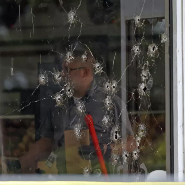 Damage can be seen to a front window law enforcement officers work the scene of a shooting at the Mad Butcher grocery store in Fordyce, Ark., Friday, June 21, 2024. (Colin Murphey/Arkansas Democrat-Gazette via AP)