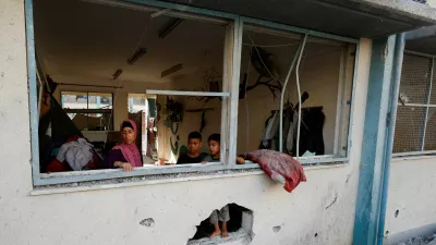 Palestinians stand near the damaged windows of a classroom in a UNRWA school, after the air strike on a neighbouring house to the school in Khan Younis, in the southern Gaza Strip, June 21, 2024. REUTERS/Mohammed Salem