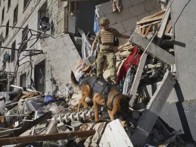 A rescue worker with a dog search for victims in a damaged apartment building after it was hit by Russian air bomb in Kharkiv, Ukraine, Saturday, June 22, 2024. At least three people were killed in a Russian bomb attack on Ukraine's second city, Kharkiv, on Saturday afternoon, Ukrainian President Volodymyr Zelenskyy said. (AP Photo/Andrii Marienko)