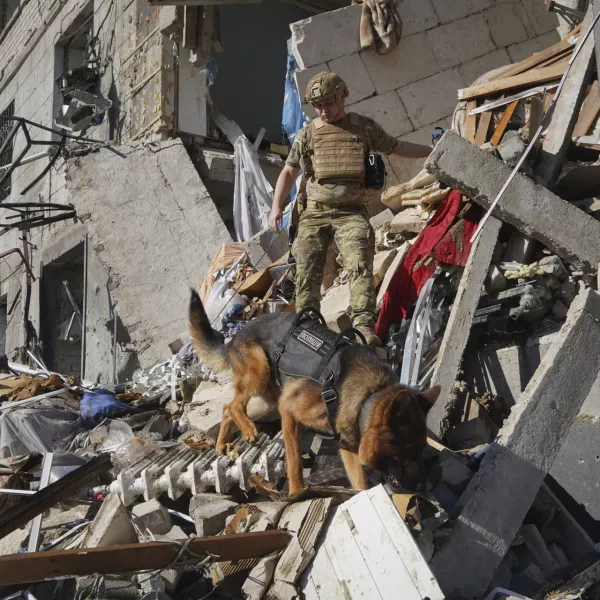 A rescue worker with a dog search for victims in a damaged apartment building after it was hit by Russian air bomb in Kharkiv, Ukraine, Saturday, June 22, 2024. At least three people were killed in a Russian bomb attack on Ukraine's second city, Kharkiv, on Saturday afternoon, Ukrainian President Volodymyr Zelenskyy said. (AP Photo/Andrii Marienko)