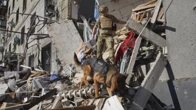 A rescue worker with a dog search for victims in a damaged apartment building after it was hit by Russian air bomb in Kharkiv, Ukraine, Saturday, June 22, 2024. At least three people were killed in a Russian bomb attack on Ukraine's second city, Kharkiv, on Saturday afternoon, Ukrainian President Volodymyr Zelenskyy said. (AP Photo/Andrii Marienko)