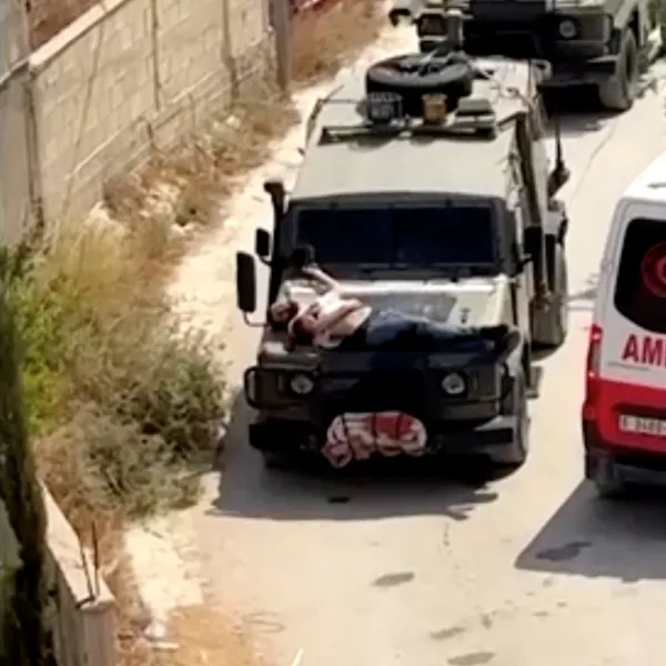 Israeli army straps Palestinian on military jeep during raid in Jenin, in this screengrab from a video, in the Israeli-occupied West Bank, June 22, 2024. REUTERS/Reuters TV