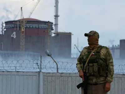 A serviceman with a Russian flag on his uniform stands guard near the Zaporizhzhia Nuclear Power Plant in the course of Ukraine-Russia conflict in the Russian-controlled city of Enerhodar in the Zaporizhzhia region, Ukraine August 4, 2022. REUTERS/Alexander Ermochenko