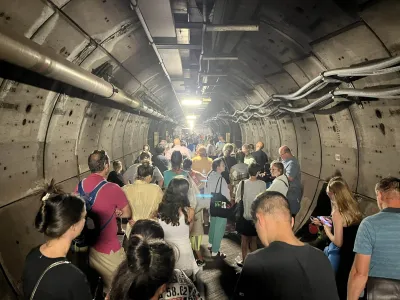 HANDOUT - 23 August 2022, ---: A handout image with permission from Kate Scott's Twitter shows passengers in an emergency tunnel of the Eurotunnel between France and England. After one of the trains broke down, passengers in the tunnel had to leave their carriages and were escorted through the emergency tunnel on foot. Photo: Kate Scott/Twitter/PA Media/dpa - ACHTUNG: Nur zur redaktionellen Verwendung.