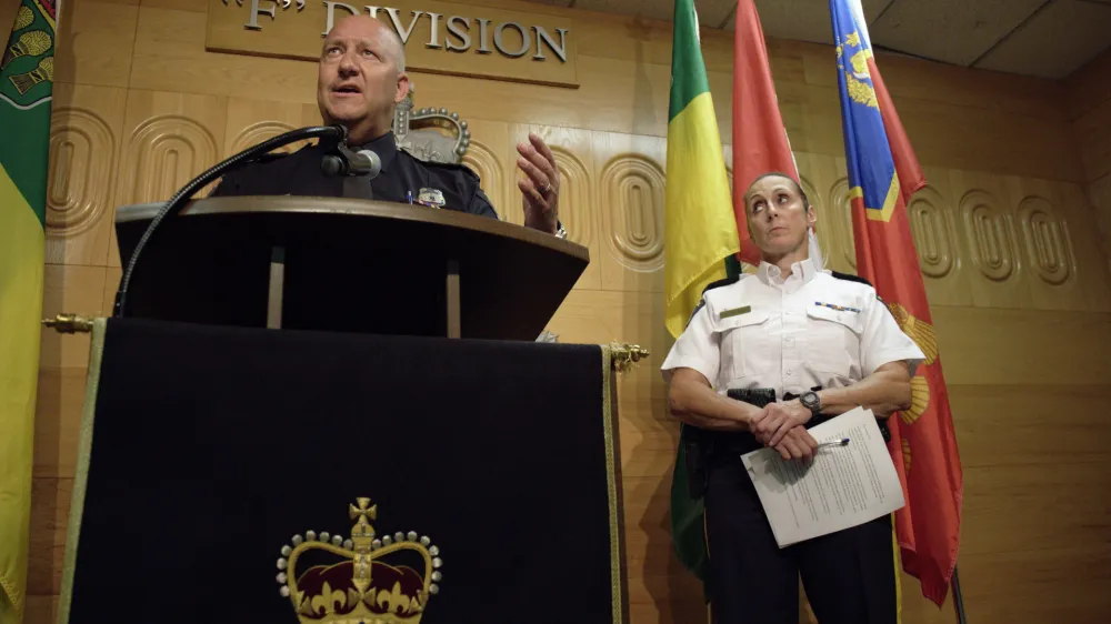 Regina Police Chief Evan Bray, left, speaks while Assistant Commissioner Rhonda Blackmore, right, looks on during a press conference at Royal Canadian Mounted Police "F" Division Headquarters in Regina, Saskatchewan, on Monday, Sept. 5, 2022. Damien Sanderson and Myles Sanderson allegedly stabbed and killed multiple people between James Smith Cree Nation and Weldon, Saskatchewan, on Sunday morning. Today, the RCMP said Damien was located deceased at the First Nation, while his brother Myles is still at large. (Michael Bell/The Canadian Press via AP)