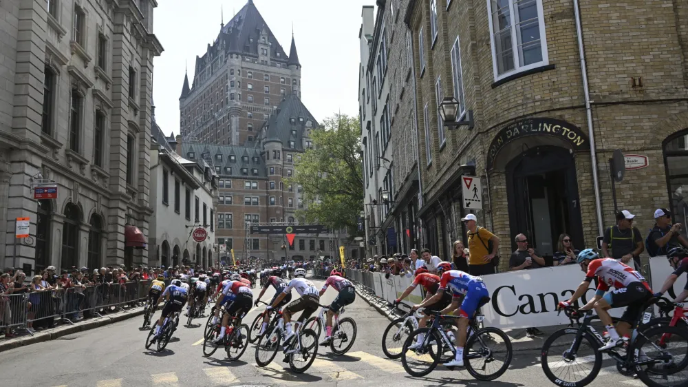 The main pack cycles up toward the Chateau Frontenac during the Grand Prix Cycliste de Quebec bicycle race, Friday, Sept. 9, 2022, in Quebec City, Canada. (Jacques Boissinot/The Canadian Press via AP)