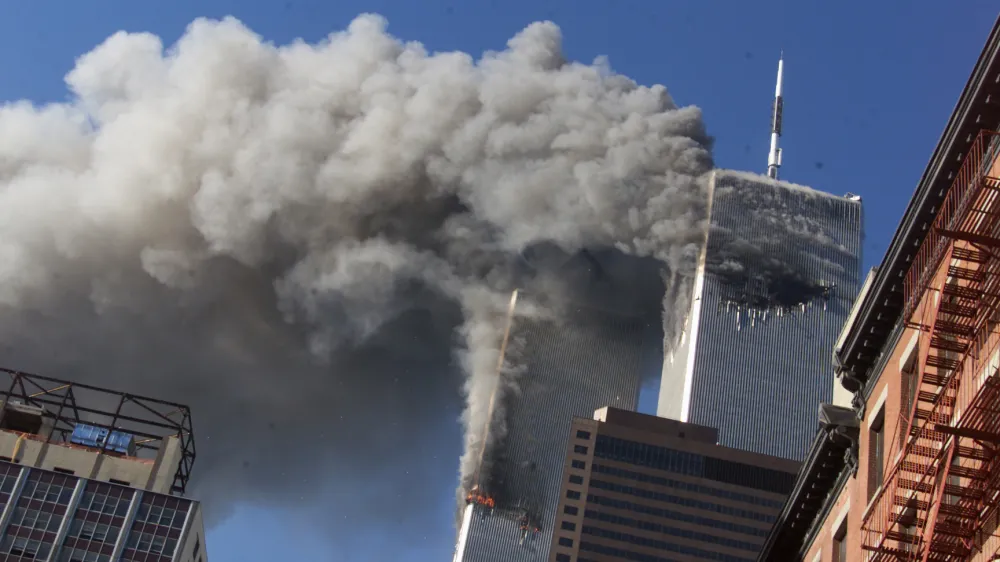 FILE - In this Sept. 11, 2001, file photo, smoke rises from the burning twin towers of the World Trade Center after hijacked planes crashed into the towers in New York City. Sept. 11 victims' relatives are greeting the news of President Donald Trump's now-canceled plan for secret talks with Afghanistan's Taliban insurgents with mixed feelings. (AP Photo/Richard Drew, File)