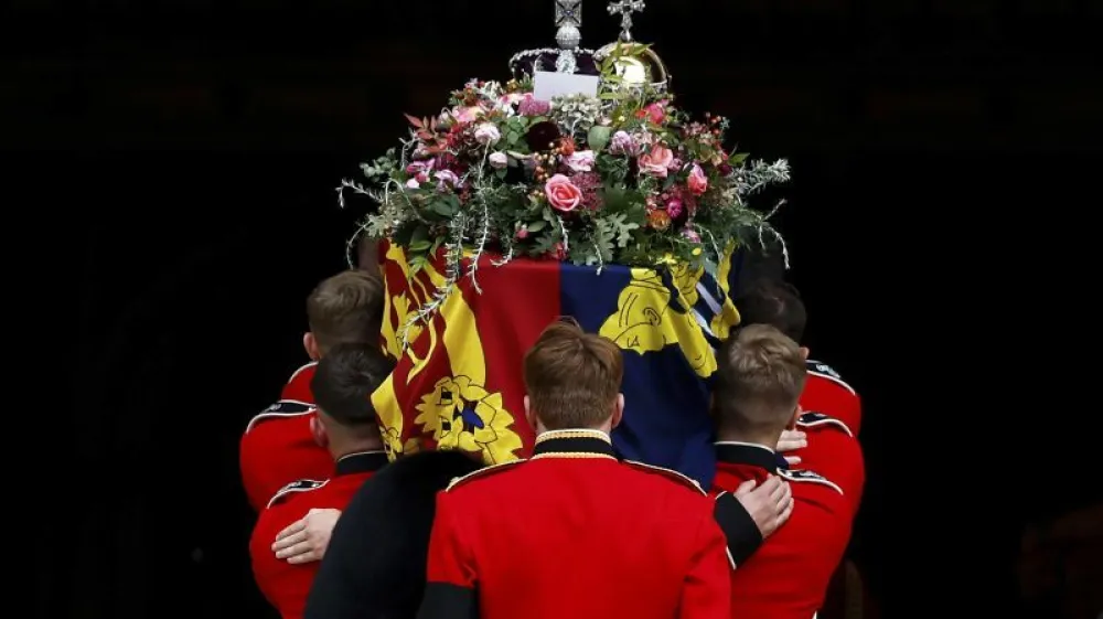 Pall bearers carry the coffin of Queen Elizabeth II with the Imperial State Crown resting on top into St. George's Chapel, in Windsor, England, Monday Sept. 19, 2022, for the committal service for Queen Elizabeth II. The Queen, who died aged 96 on Sept. 8, will be buried at Windsor alongside her late husband, Prince Philip, who died last year. (Jeff J Mitchell/Pool Photo via AP)