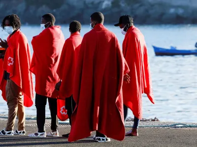 A group of migrants walks to a Red Cross tent to be attended after disembark from a Spanish coast guard vessel, in the port of Arguineguin, in the island of Gran Canaria, Spain, September 21, 2022. REUTERS/Borja Suarez