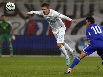 Cyprus' Constantinos Charalambides, right, is challenged by Slovenia's Josip Ilicic during their World Cup Group E qualifying soccer match at Ludski Vrt stadium in Maribor, Slovenia, Friday, Oct. 12, 2012. (AP Photo/Darko Bandic)