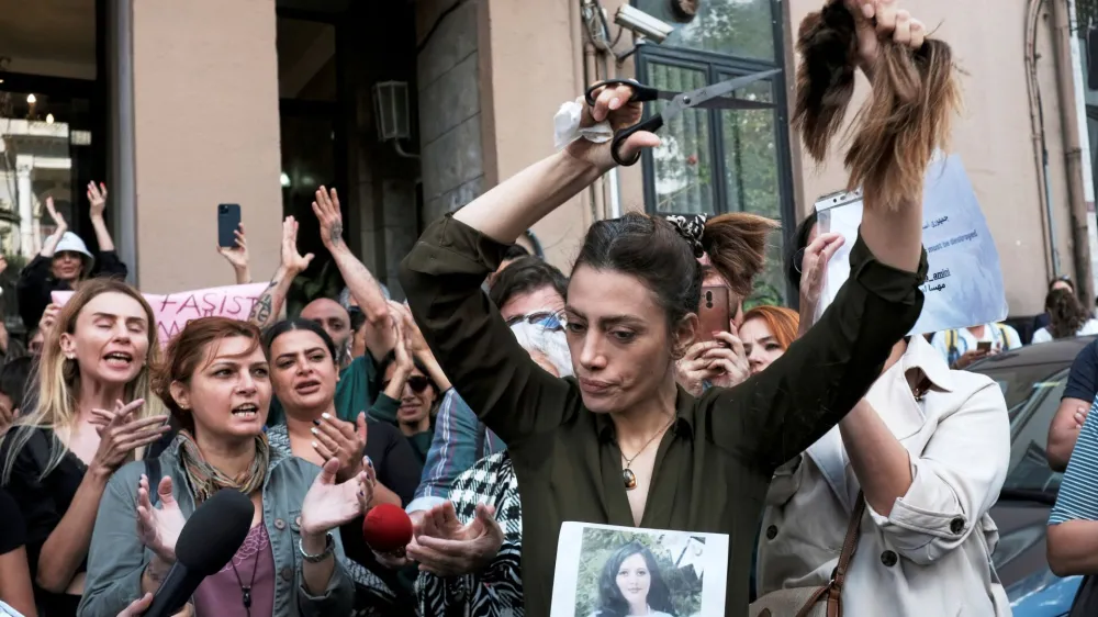 Nasibe Samsaei, an Iranian woman living in Turkey, cuts her hair during a protest following the death of Mahsa Amini, outside the Iranian consulate in Istanbul, Turkey September 21, 2022. REUTERS/Murad Sezer