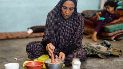 A displaced Palestinian woman prepares food at a school classroom where she shelters, amid food scarcity, as Israel-Hamas conflict continues, in Khan Younis in the southern Gaza Strip, June 26, 2024. REUTERS/Mohammed Salem