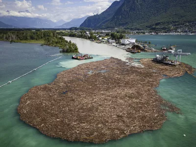 Excavators on barges collect and sort an estimated 7,000 to 9,000 cubic meters of wood at the mouth of the Rhone river on Lake Geneva in le Bouveret, Switzerland, Monday, June 24, 2024. Heavy and unusually intense rainfalls over the last days in the canton of Valais have produced numerous floods and landslides with a large volume of floating wood carried along the Rhone river to Lake Geneva. (Valentin Flauraud/Keystone via AP)