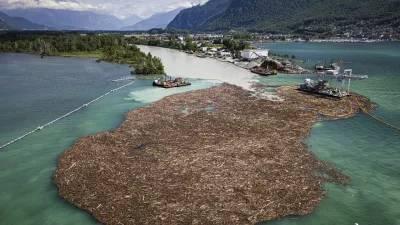 Excavators on barges collect and sort an estimated 7,000 to 9,000 cubic meters of wood at the mouth of the Rhone river on Lake Geneva in le Bouveret, Switzerland, Monday, June 24, 2024. Heavy and unusually intense rainfalls over the last days in the canton of Valais have produced numerous floods and landslides with a large volume of floating wood carried along the Rhone river to Lake Geneva. (Valentin Flauraud/Keystone via AP)