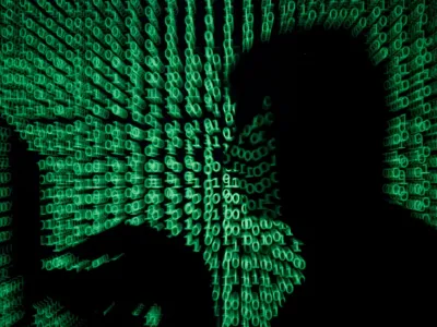 FILE PHOTO: A man holds a laptop computer as cyber code is projected on him in this illustration picture taken on May 13, 2017. REUTERS/Kacper Pempel/Illustration/File Photo