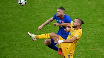 26 June 2024, Hesse, Frankfurt_Main: Romania's George Puscas (R) and Milan Skriniar of Slovakia fight for the ball during the UEFA Euro 2024 Group E soccer match between Slovakia and Romania at Frankfurt Arena. Photo: Torsten Silz/dpa