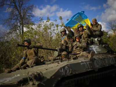 Ukrainian soldiers sit on an armoured vehicle as they drive on a road between Izium and Lyman in Ukraine, Tuesday Oct. 4, 2022. (AP Photo/Francisco Seco)