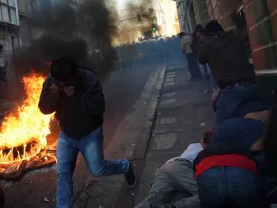 People cover their faces while demonstrators face members of Bolivia's military, as Bolivia's President Luis Arce "denounced the irregular mobilization" of some units of the country's army, in La Paz, Bolivia, June 26, 2024. REUTERS/Claudia Morales