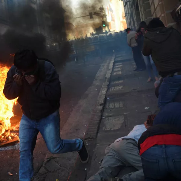 People cover their faces while demonstrators face members of Bolivia's military, as Bolivia's President Luis Arce "denounced the irregular mobilization" of some units of the country's army, in La Paz, Bolivia, June 26, 2024. REUTERS/Claudia Morales