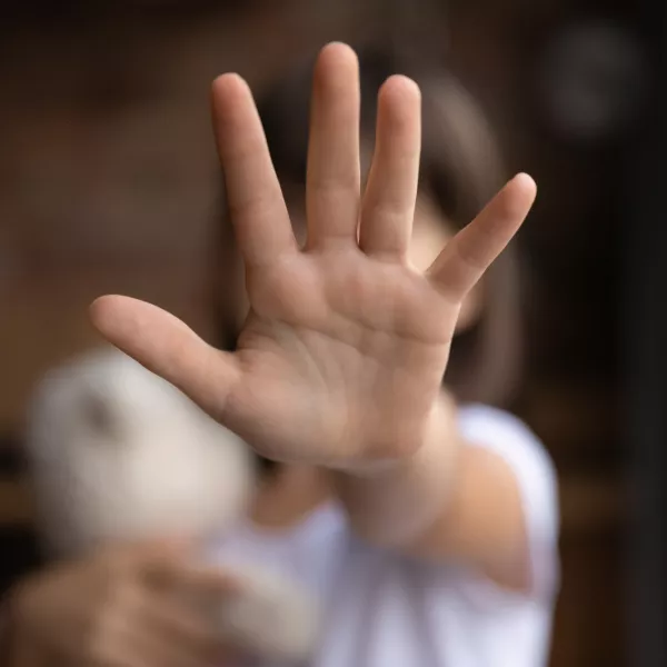 Crop close up of little girl child stretch hand show no gesture protest against domestic violence. Small teen child stand against discrimination or school abuse. Childhood problem, voice concept.