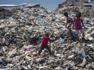 Palestinian kids sort through trash at a landfill in Nuseirat refugee camp, Gaza Strip, Thursday, June 20, 2024. Israel's war in Gaza has decimated the strip's sanitation system while simultaneously displacing the vast majority of the population, leaving many Palestinians living in tent camps nearby water contaminated with sewage and growing piles of garbage. (AP Photo/Abdel Kareem Hana)